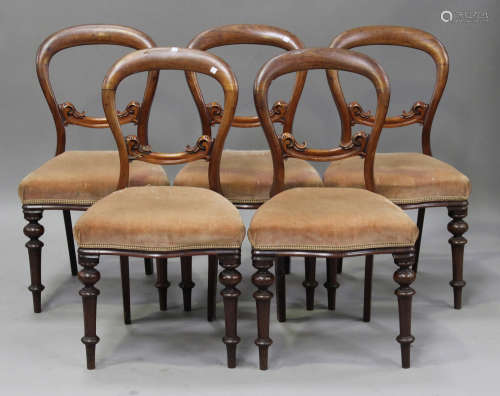 A set of five Victorian mahogany dining chairs, the overstuffed seats raised on turned legs,