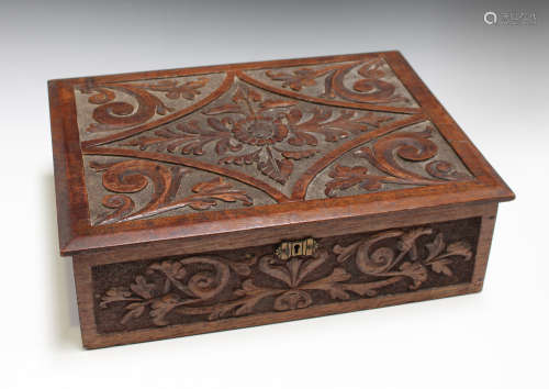 An early 20th century carved walnut box, the hinged lid and sides decorated in relief with