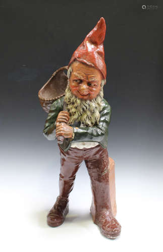 An early 20th century Continental painted and cast composition figure of a gnome, modelled holding a