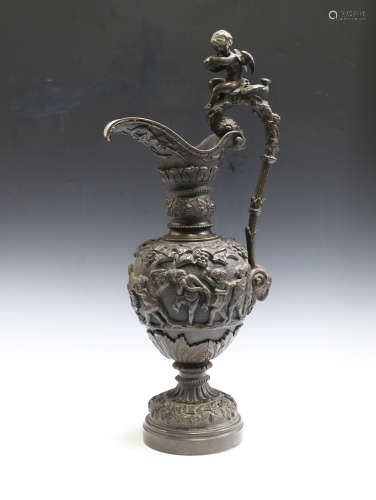 A late 19th century brown patinated cast bronze ornamental ewer, the scrolling handle surmounted