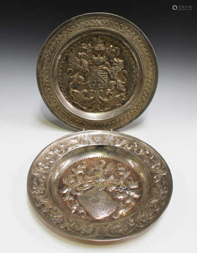 Two silvered and partially gilded dishes, both decorated with heraldic crests, diameter 35cm.Buyer’s