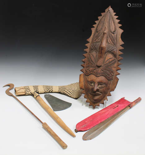 A Papua New Guinea ceremonial axe, mid-20th century, the carved green stone head bound in woven