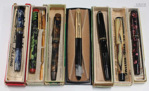 A group of various fountain pens, including a Golden Guinea visible-filling pen, a Wyvern No. 81