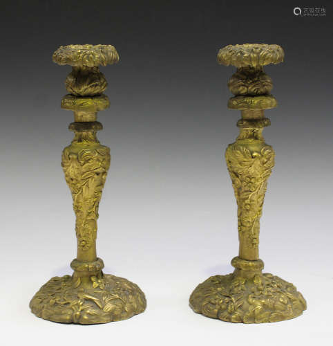 A pair of French Rococo style cast ormolu candlesticks, decorated in relief with birds, flowers