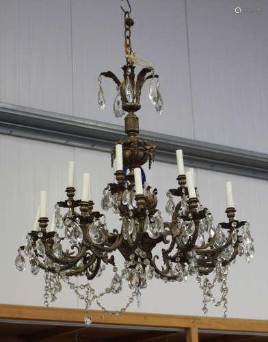 A 20th century cast gilt metal eighteen-light chandelier, hung with overall cut glass tear shaped