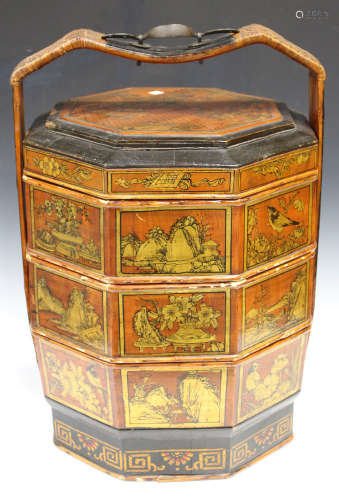 A 20th century Chinese lacquered wooden stacking food carrier, the sides gilded with landscape