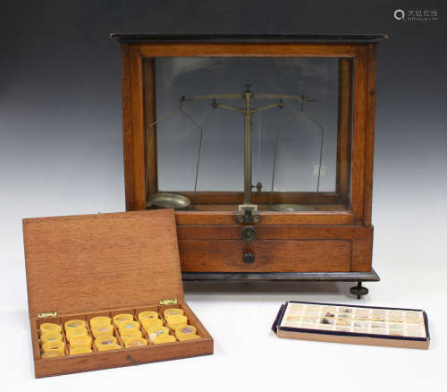 A set of early 20th century scientific balance scales within a glazed cabinet, width 41cm,