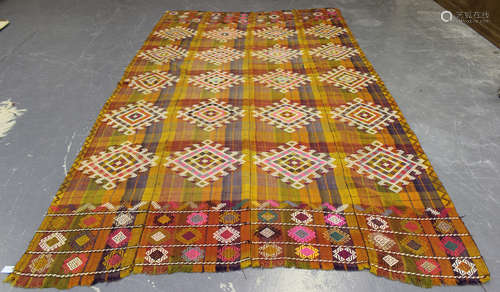 A Turkish embroidered and woven polychrome throw, worked with overall hooked guls on a checked