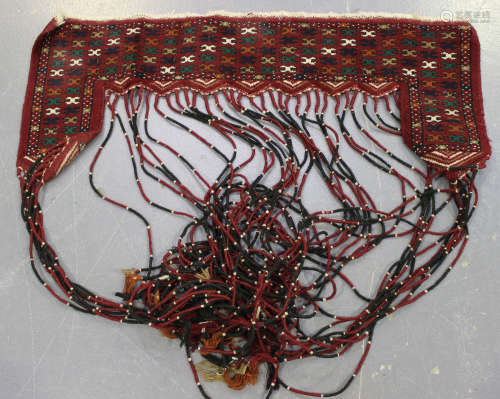 A Turkestan door hanging, hung with a long tasselled fringe, width 110cm, together with a