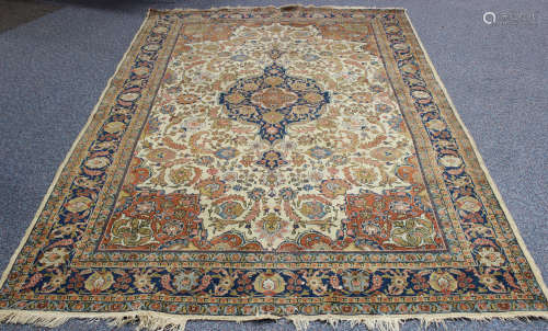 A Tabriz carpet, Central Persia, early 20th century, the ivory field with a shaped blue medallion,