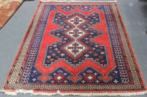 An Afshar rug, South-west Persia, late 20th century, the red field with three hooked medallions,