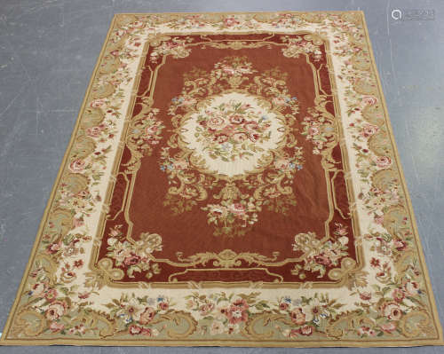 An Aubusson style flatweave rug, late 20th century, the terracotta field with a floral medallion,