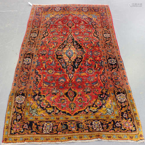 A Kashan rug, Central Persia, mid-20th century, the shaded red field with a shaped medallion,