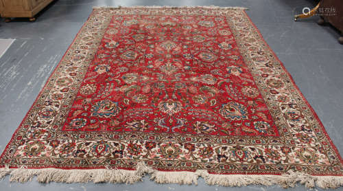 A Tabriz carpet, Central Persia, mid-20th century, the red field with overall scrolling tendrils and