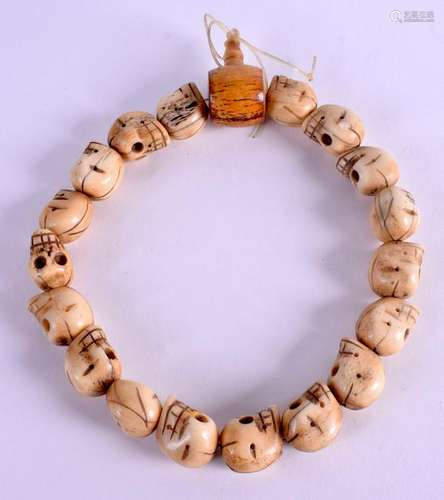 AN ASIAN CARVED BONE SKULL NECKLACE. 34 cm long.