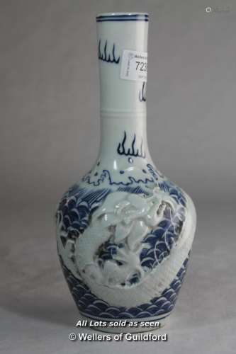 A Chinese blue and white bottle vase repousse with a dragon, impressed mark to base, 23.5cm.