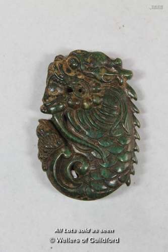 A Chinese green hardstone pendant carved as a dragon.