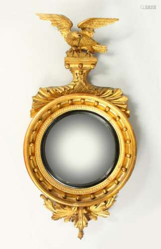 A REGENCY GILTWOOD CONVEX WALL MIRROR, with eagle