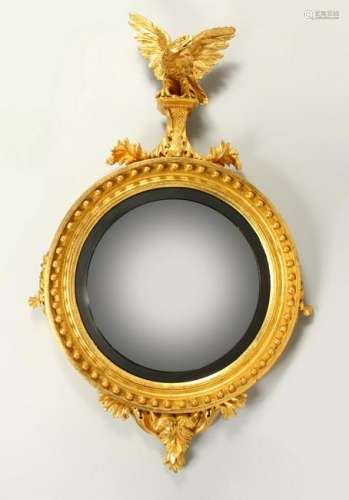 A REGENCY GILTWOOD CONVEX WALL MIRROR, with eagle