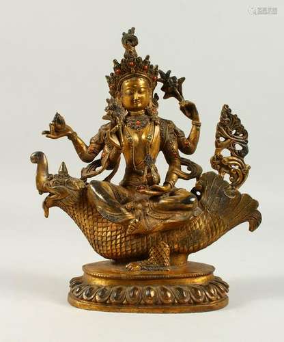 A GILT BRONZE MULTI ARM DEITY, seated on the back of a