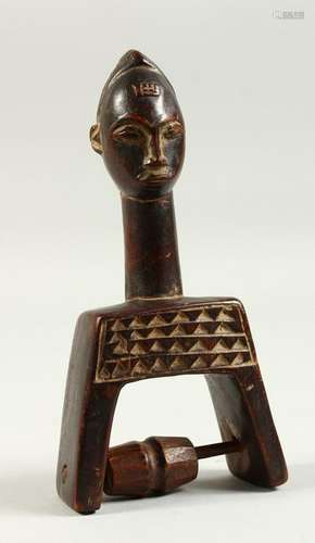 AN AFRICAN CARVED WOOD FIGURAL PULLEY.  16cms high.