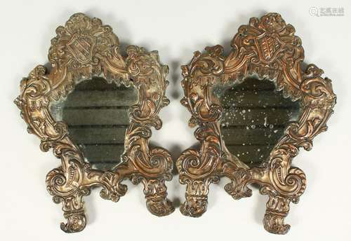 A PAIR OF ITALIAN METAL SHAPED MIRRORS, with crest and