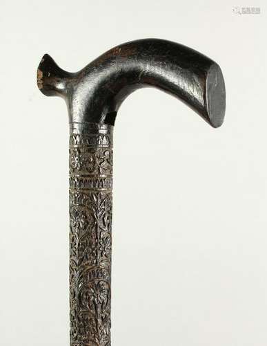 A CEYLONESE CARVED EBONY WALKING CANE.  95cms long.