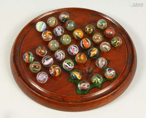 A WOODEN SOLITAIRE BOARD, with a complete set of 