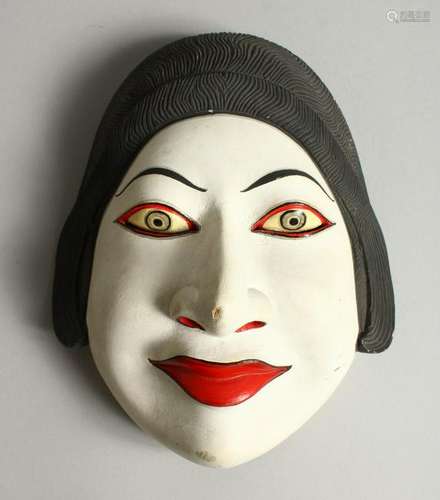 A CARVED AND PAINTED WOOD MASK OF A WOMAN.  20.5cms