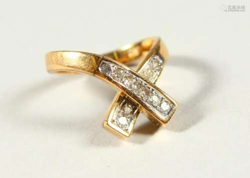 A 14CT GOLD AND DIAMOND CROSSOVER RING.