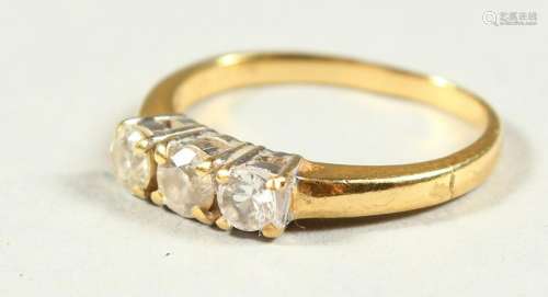 AN 18CT GOLD THREE STONE DIAMOND RING.