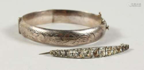 A SILVER BANGLE AND A BROOCH.