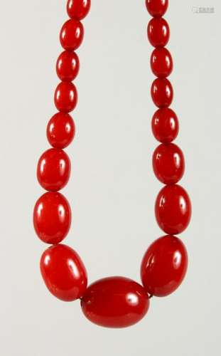 A RED AMBER BEAD NECKLACE.  Largest Bead: 30mm.