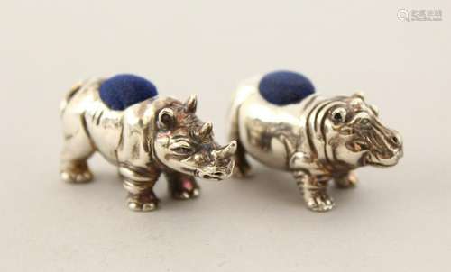 A SILVER RHINO AND HIPPO PIN CUSHION.