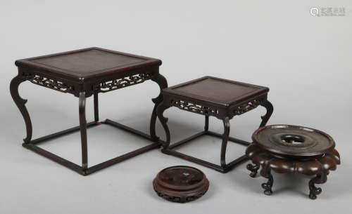 Two Chinese graduated carved hardwood ornament stands of square form. Each with a pierced frieze and