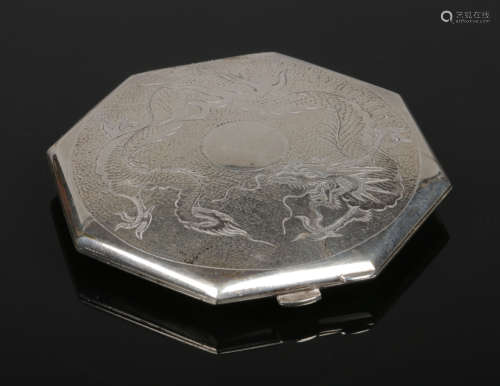 A Chinese octagonal silver powder compact. With a planished top engraved with a dragon chasing its