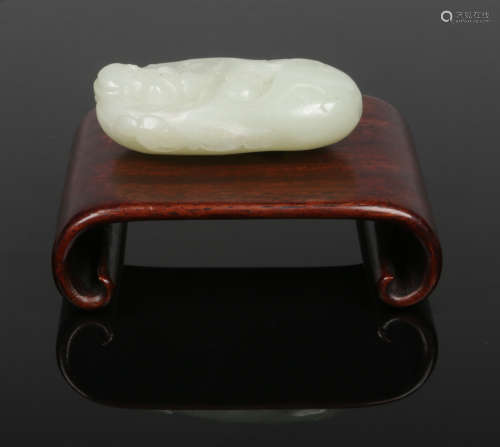 A Chinese pale celadon jade carving of a sage dressed in a robe and flanked by a pair of ruyi