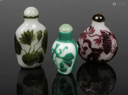 Three Chinese Peking cameo glass snuff bottles, all well hollowed. Emerald, amethyst and olive,
