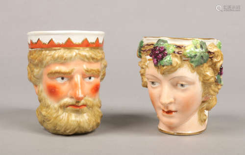 A 19th century Derby mask jug formed as Jupiter and coloured in enamels along with a similar