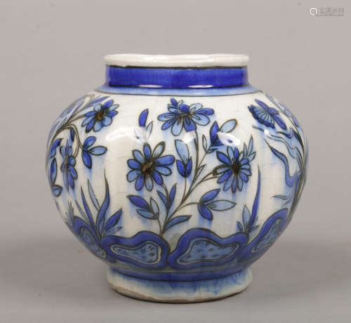 A Turkish Iznik style lobed vase. Painted with stylized flowers in blue glazes, 14cm.Condition