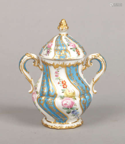 A Sevres style twin handled jar and cover. Wrythen moulded, gilded, with turquoise ground bands