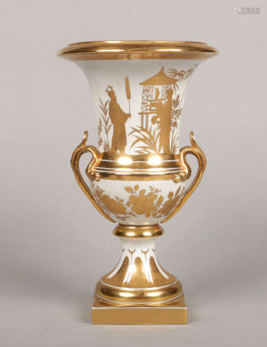A 20th century Continental porcelain twin handled urn. Decorated in gilt with a chinoiserie scene.