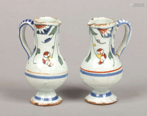 A pair of small 19th century Continental polychrome delft ewers painted with flowers, 10.75cm.