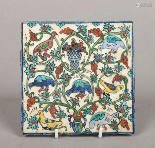 An antique Turkish Iznik style tile. Painted in coloured enamels with birds, fruit and flowers, 15.