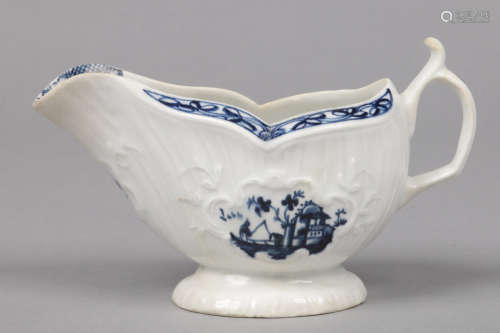 An Isleworth pleat moulded sauceboat. Painted in underglaze blue with panels containing fishermen