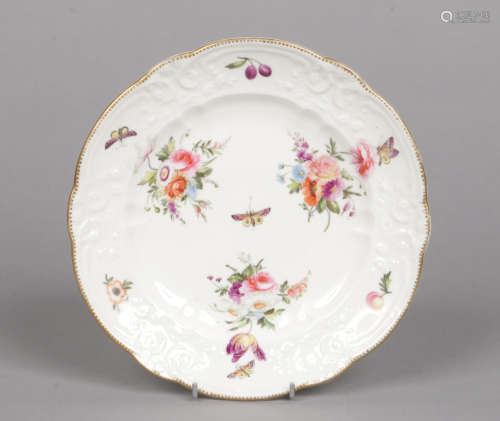A Swansea plate with scalloped rim and moulded with scrolls. Painted with flower bouquets,