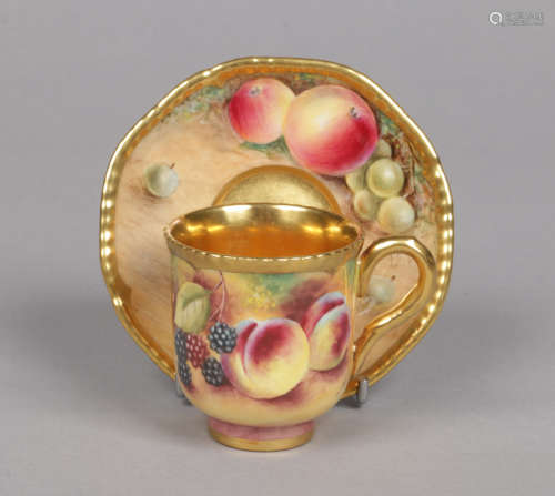 A Royal Worcester coffee cup and saucer. With gilded gadroon moulded rims and painted with fruit
