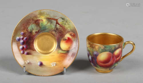 A Royal Worcester miniature coffee cup and saucer painted with fruit. Signed by Cole and Price.