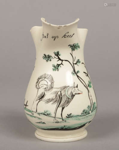An 18th century creamware jug with entwined reeded strap handle. Painted in coloured enamels with