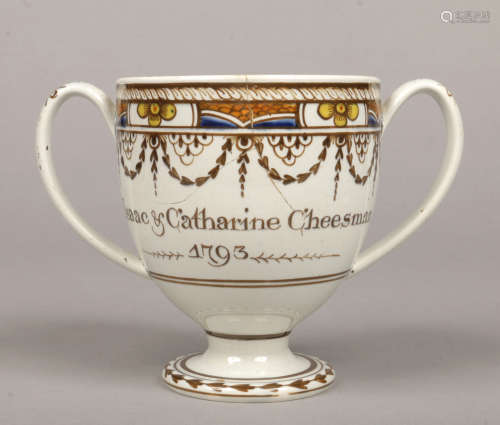 A documentary Swinton pottery pearlware loving cup. Painted with a gadroon, flower and husk swag